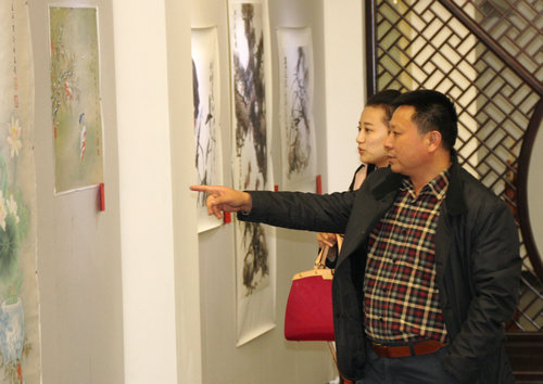 现场的参观者仔细观看画展