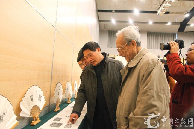贾文忠为谢辰生讲解拓印作品