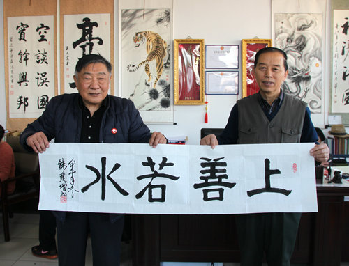武警韩双增将军向书画院执行院长杨书元赠送《上善若水》